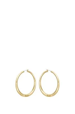 Pendientes de aro dorados con detalle de la marca